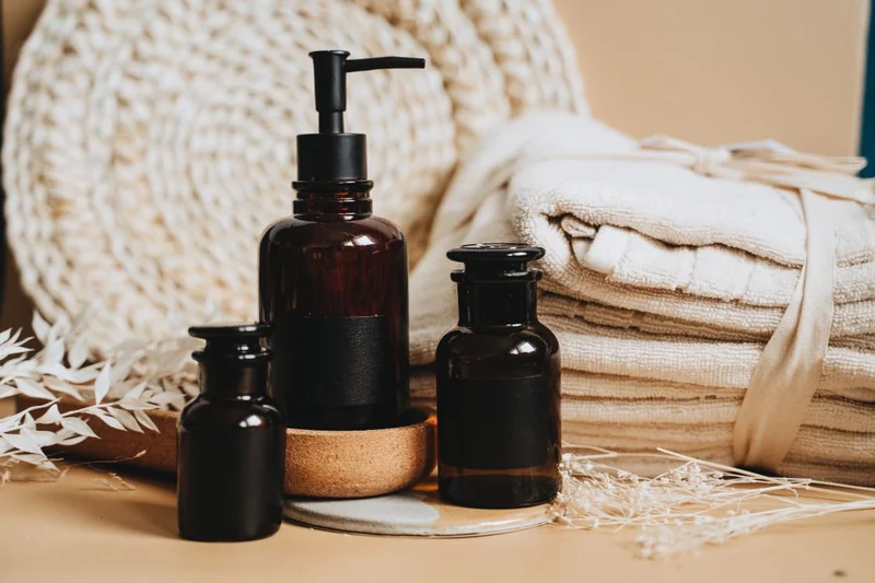 Folded cream towels and amber bottles